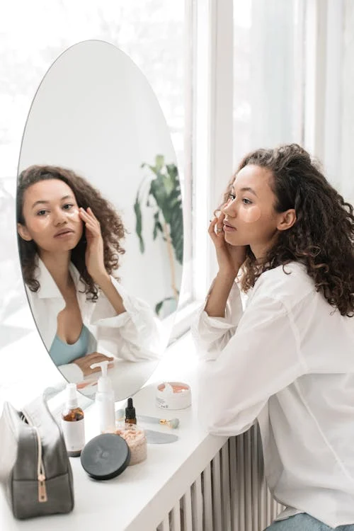 Cliente utilise les produits cosmétiques en s'aidant de son miroir ; marché cosmétique afrique ; fournisseur beauty shop afrique ; produits hygiéniques afrique